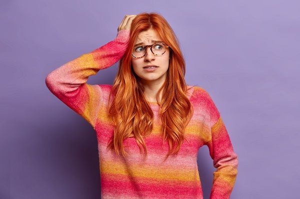 Mujer con cara preocupada y la mano en la cabeza