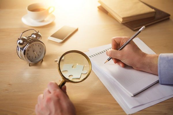 Persona con lupa representando la investigación y análisis antes de hacer una apuesta deportiva