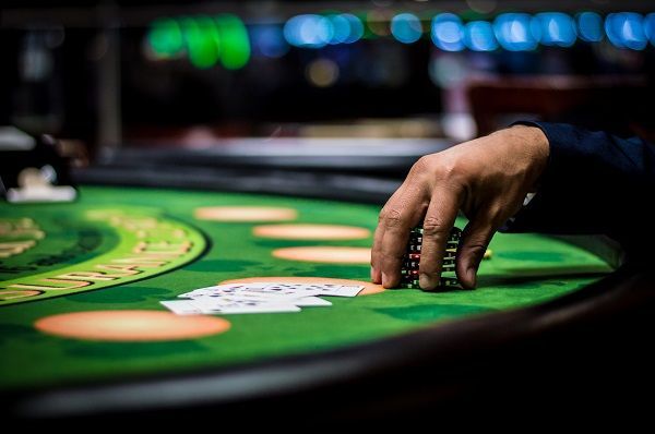 Mano cogiendo fichas para apostar al blackjack