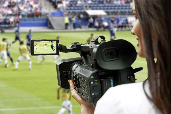 Mujer con cámara grabando un partido de fútbol representando las noticias del deporte de última hora