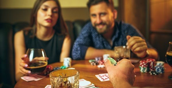 Grupo de amigos jugando al póker con fichas y cartas sobre una mesa