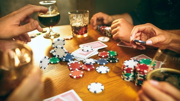 Mesa de póker entre amigos con fichas, cartas y bebidas
